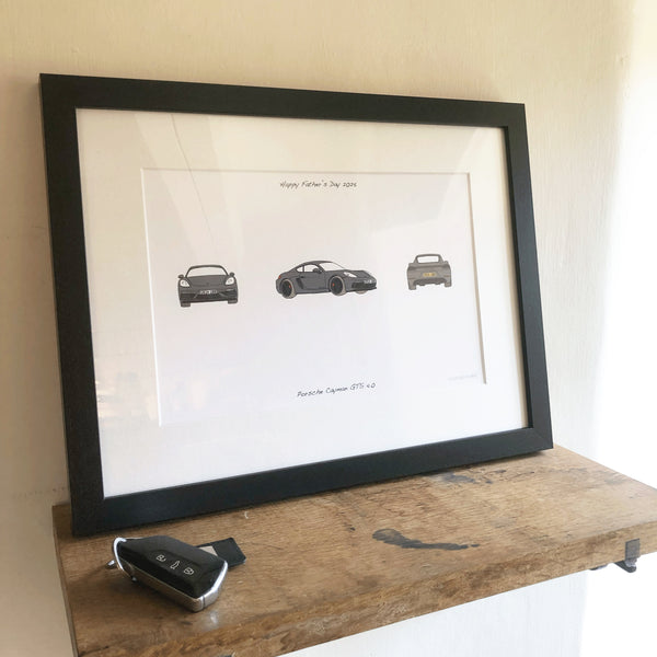 Framed artwork of three cars on a wooden shelf.